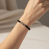 Black baguette tennis bracelet on a person's hand