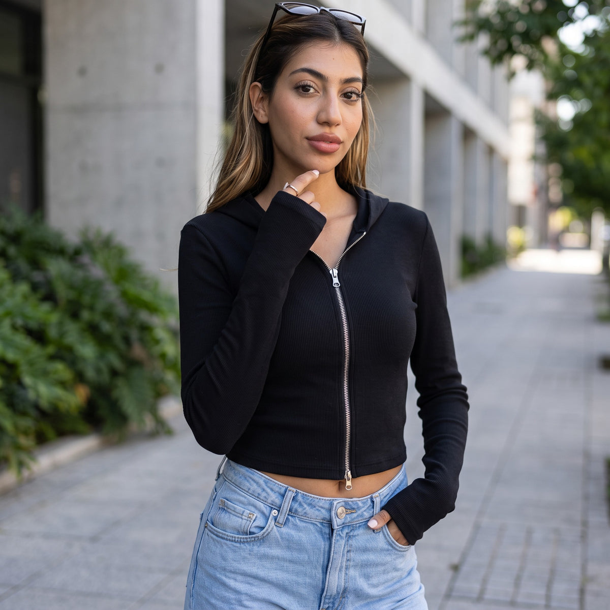 Black ribbed knit zip hoodie with a cropped hem and silver zip, worn with light jeans