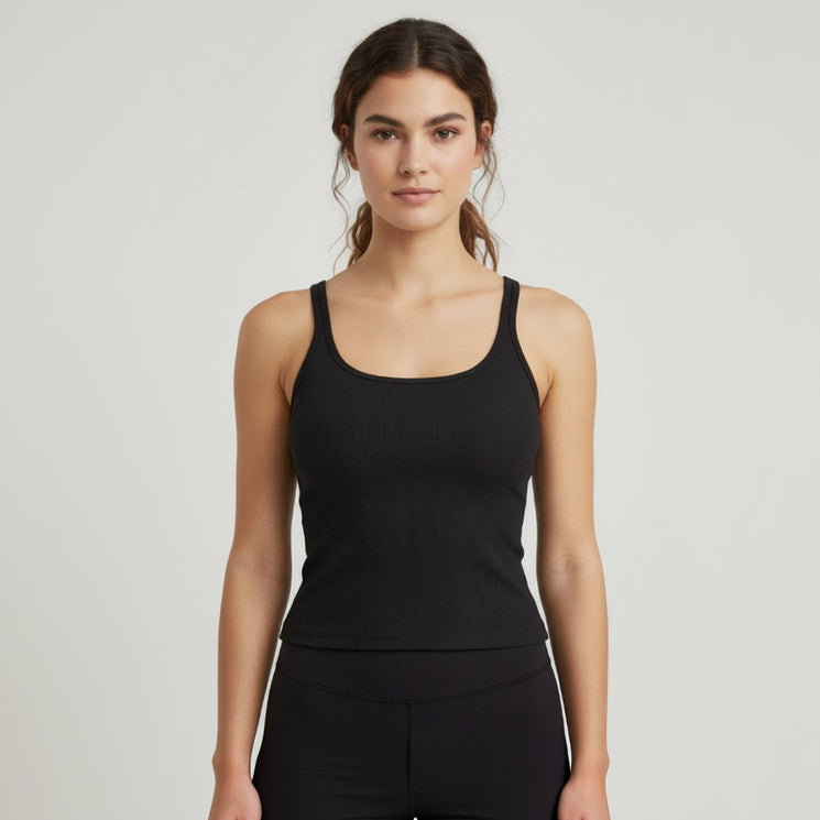 Woman wearing a black ribbed tank top against a plain background