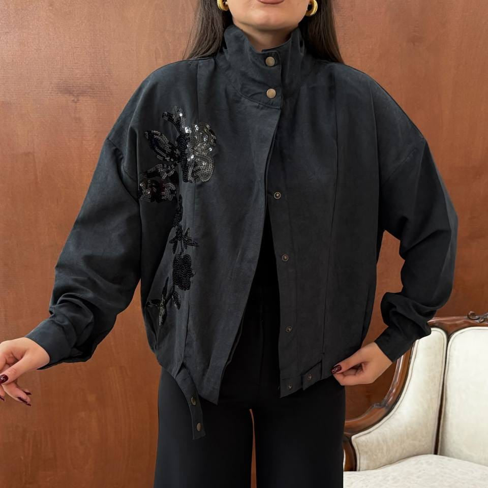 Black oversized jacket with sequin flowers, a high snap collar and snap front worn open