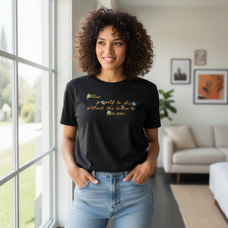 Woman wearing a black tshirt with colorful text in a living room setting