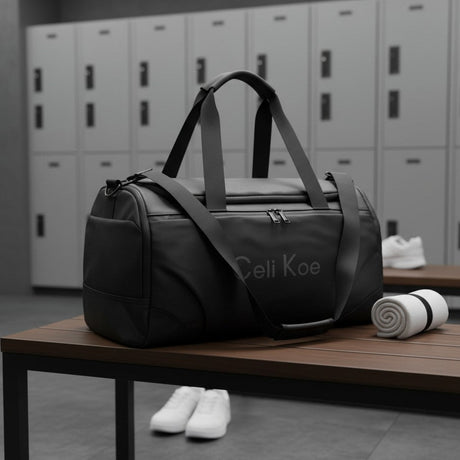 A black duffle bag with grey handles and a grey printed logo sits on a wooden bench in a gym setting
