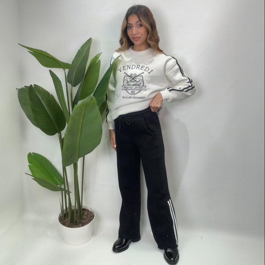 Full length view of a white varsity sweatshirt with black side stripe wide leg pants and loafers