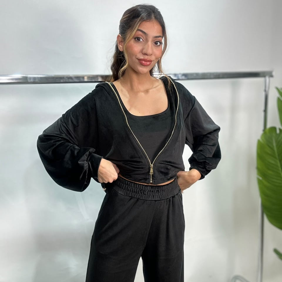 Black velvet zip jacket with gold zip and balloon sleeves worn with hands on hips