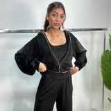 Black velvet zip jacket with gold zip and balloon sleeves worn with hands on hips