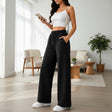 Woman wearing black wide leg sweatpants with a drawstring waist indoors