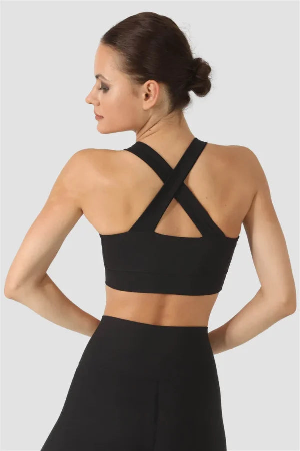 Woman wearing a black sports bra and leggings on a white background