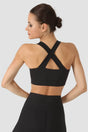 Woman wearing a black sports bra and leggings on a white background