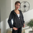 Black brushed fleece zip up hoodie worn open over a white tank with black sweatpants