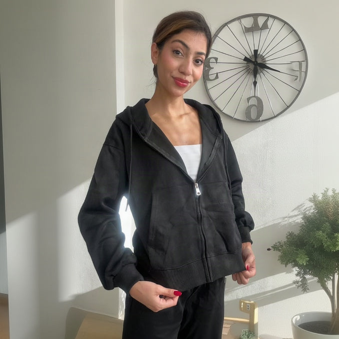 Black brushed fleece zip up hoodie worn open over a white tank with black sweatpants