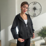 Black brushed fleece zip up hoodie worn open over a white tank with black sweatpants