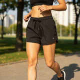 Person running wearing black active shorts outdoors on a path
