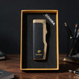 Slim matte black cigar lighter with a polished gold top and side in a gold edged box