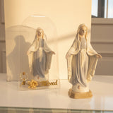 Two Marian statues in powder blue and cream, one inside a clear arched case