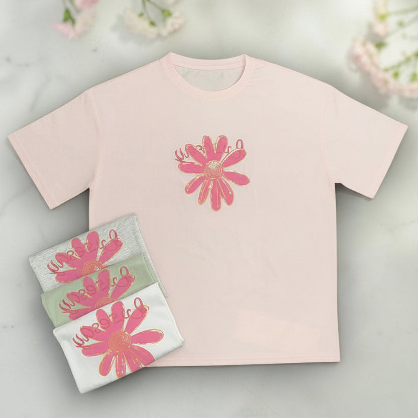 Pink tshirt with floral design with flowers in the background