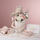 The butterfly bust vase beside blush gift boxes tied with soft pink satin bows