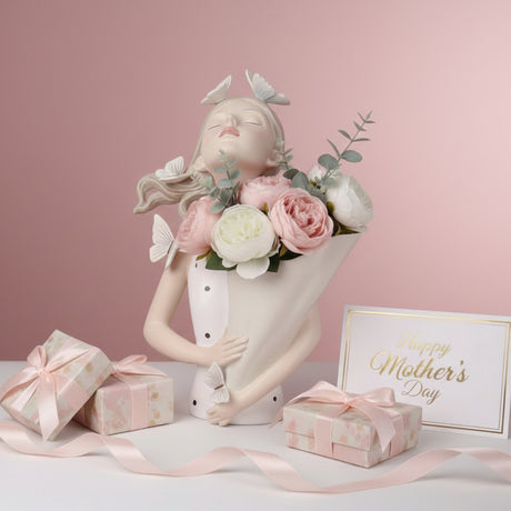 The butterfly bust vase beside blush gift boxes tied with soft pink satin bows
