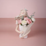 Cream bust vase with white butterflies in her hair, her paper cone full of roses