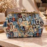 Blue and cream tapestry handbag with Armenian letters, brass kiss clasp and chain strap on a marble vanity