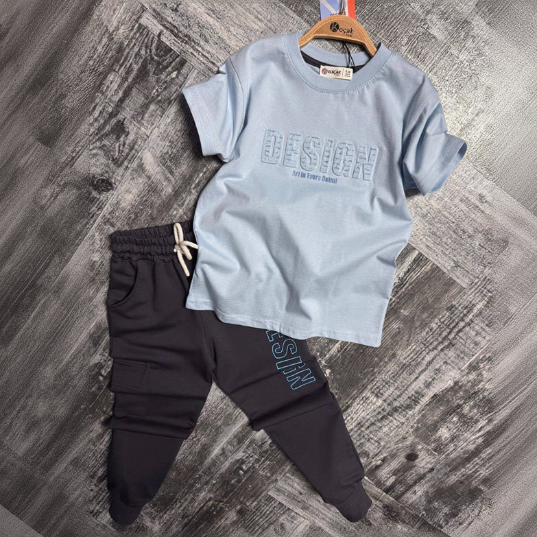Light blue Design print tee and dark navy cargo joggers laid flat, boys two piece set