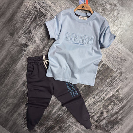 Light blue Design print tee and dark navy cargo joggers laid flat, boys two piece set