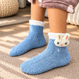 Blue fuzzy kids socks with a white cuff and a plush bunny face with carrot ears