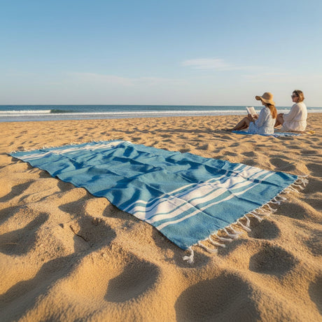 Two people sitting on a sandy beach with a blue towel and 'Beach Mode' text overlay.