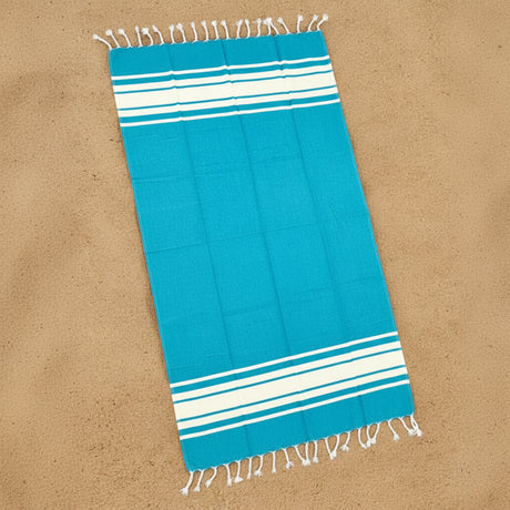 Blue towel with white stripes on a sandy background
