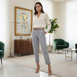 Woman in a white blouse and blue pants standing in a stylish living room