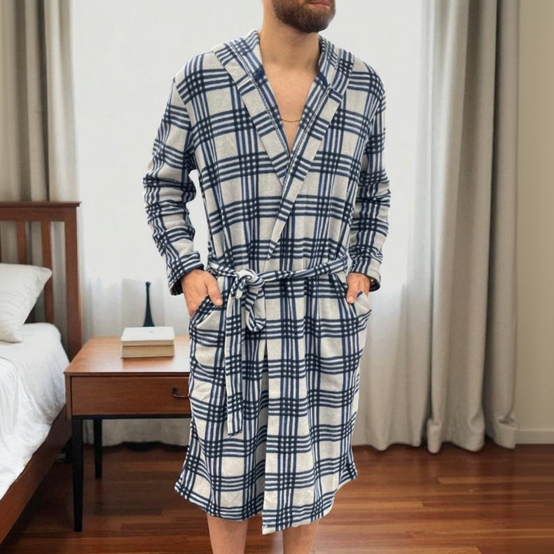 Blue checkered fleece robe worn standing beside a bed, belt tied at the waist