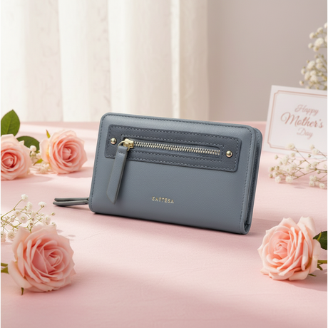 Blue wallet on a pink surface with pink roses and a 'Happy Mother's Day' card in the background