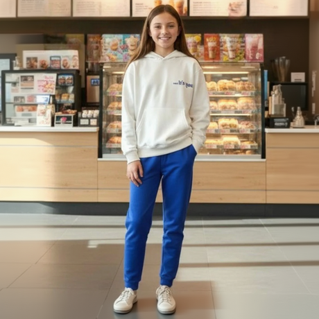 Girl in a cream oversized hoodie and blue joggers