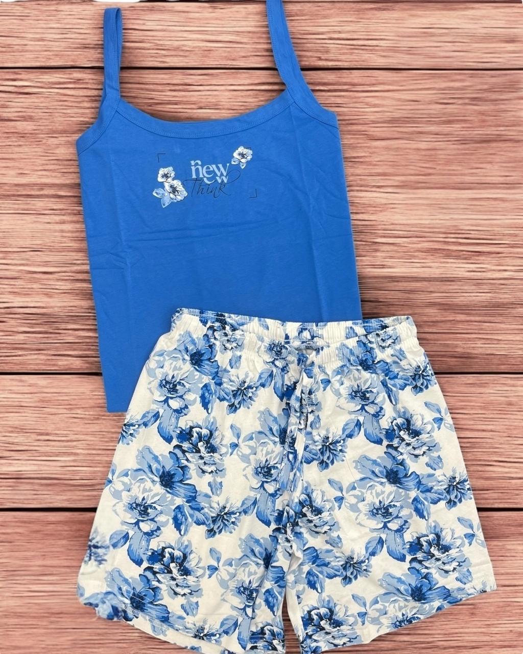 Blue tank top and floral shorts set on a wooden surface