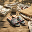 Pale blue floral tapestry slide sandals on a wooden deck