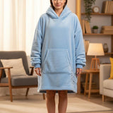 Person wearing a light blue hoodie dress in a living room setting
