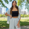 Powder blue lace trim set worn with a black top, jacket carried over the arm in a park