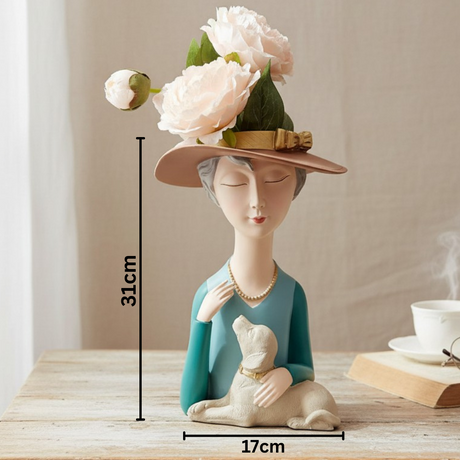 Teal bust vase of a woman in a blush hat with a small dog on her lap, marked 31cm by 17cm