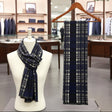 Navy blue plaid scarf on a mannequin and hanger in a store setting