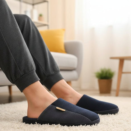 Person wearing navy blue slippers in a living room setting