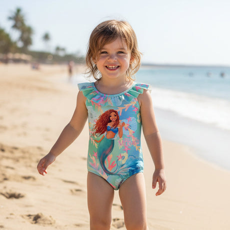 Toddler wearing a blue mermaid print onepiece swimsuit on the beach