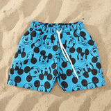 Blue shorts with black and white Mickey Mouse pattern on a gray surface