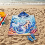 Royal blue mermaid poncho towel with clownfish, bubbles and a coral reef flat lay