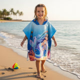 Girl walking on wet sand in a royal blue mermaid hooded poncho towel