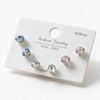 Three pairs of faceted round crystal studs in light blue, clear and pink on a white card