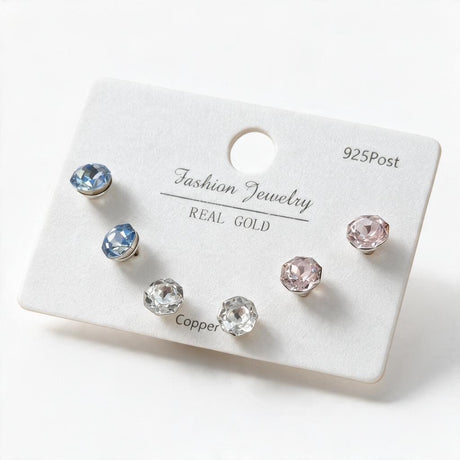 Three pairs of faceted round crystal studs in light blue, clear and pink on a white card