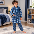 Boy in a blue plaid fleece robe with a matching blue pyjama top and trousers