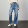 Person wearing blue jeans with white side-stripes on a gray background