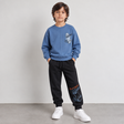 Boy in a blue skateboard sweatshirt and black printed joggers, front view