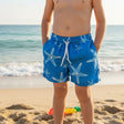 Bright blue swim shorts with white starfish print for boys