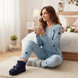 Woman in a blue star print pyjama set holding a mug in a cozy bedroom - Jack Gifts Online Lebanon